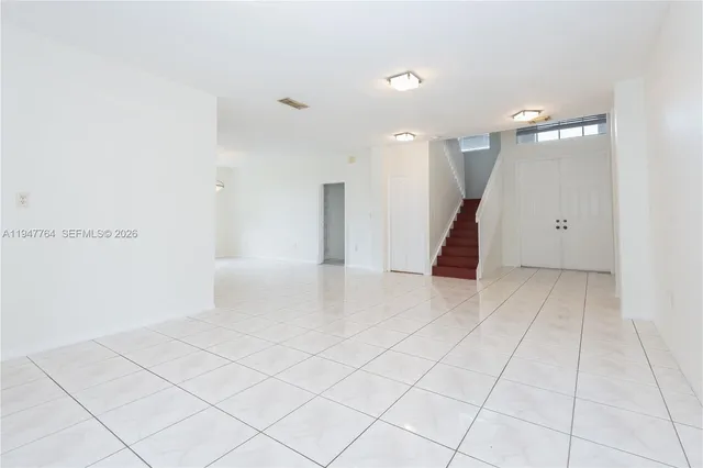 an empty room with white walls and tiles
