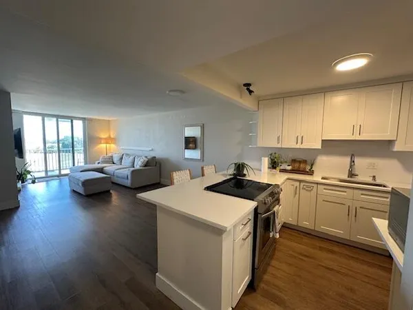 a kitchen with sink stove and wooden floor