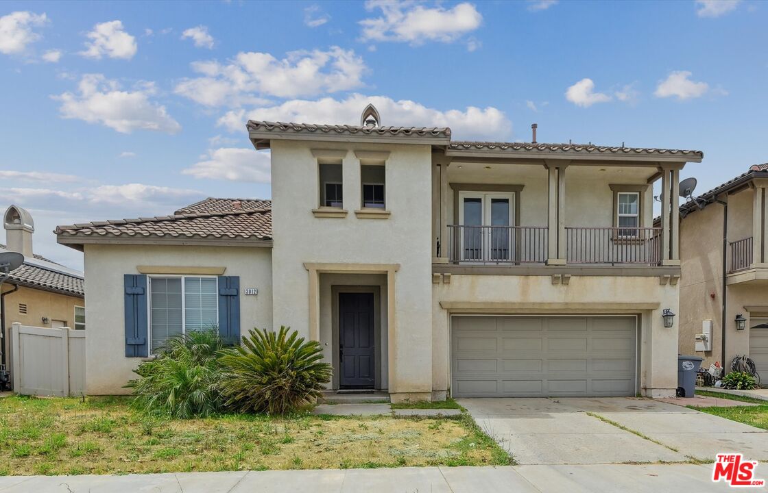 a view of a white house with large windows and a small yard