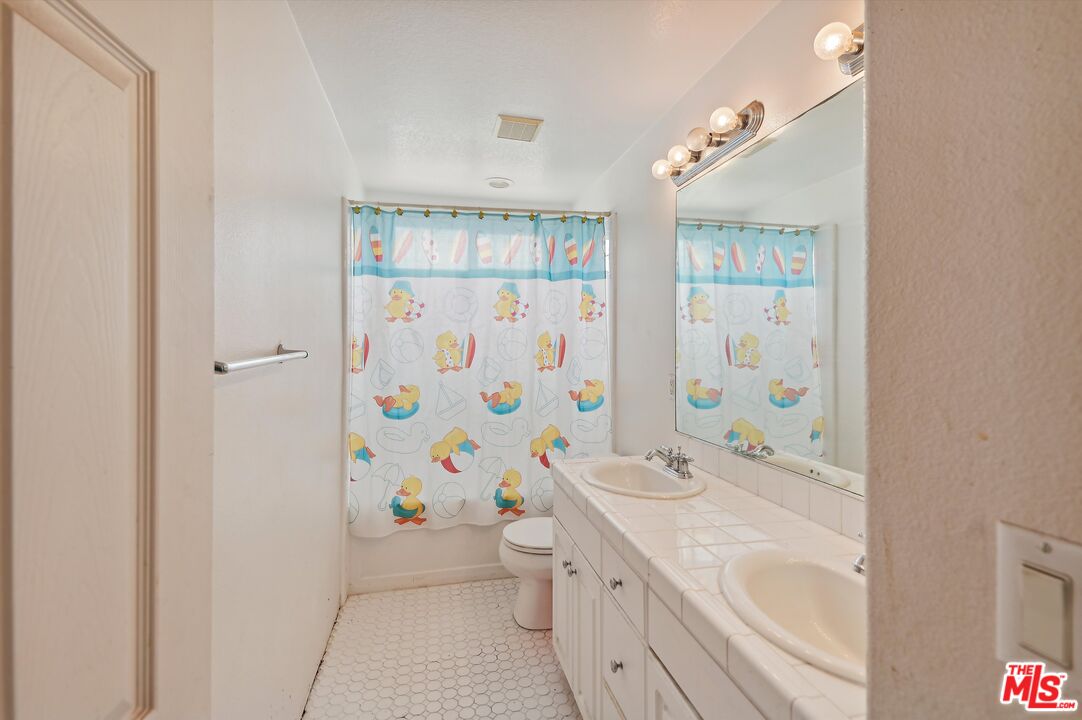 3012 Dunkirk Drive Oxnard, CA 93035 - Photo 11 of 29 a bathroom with a sink a toilet and shower curtain