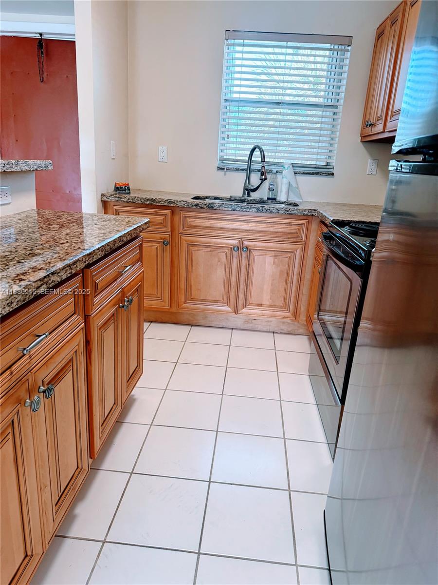 a kitchen with stainless steel appliances granite countertop a sink stove and cabinets