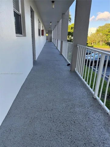 a view of a hallway with wooden floor and windows