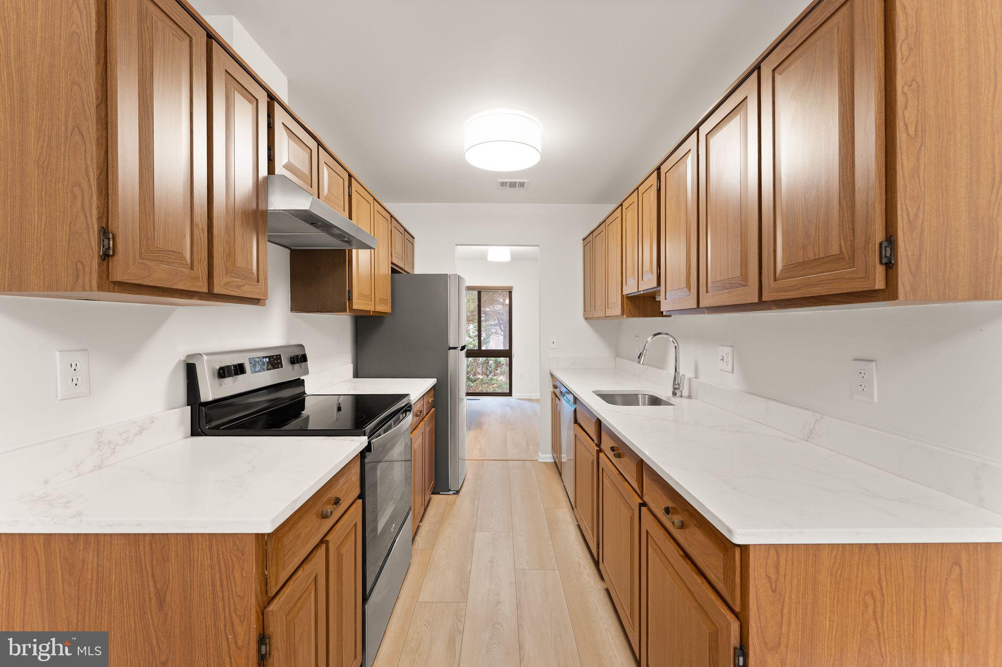2345 Millennium Lane Reston, VA 20191 - Photo 2 of 55 a kitchen with stainless steel appliances granite countertop a refrigerator a stove top oven a sink dishwasher and wooden cabinets with wooden floor