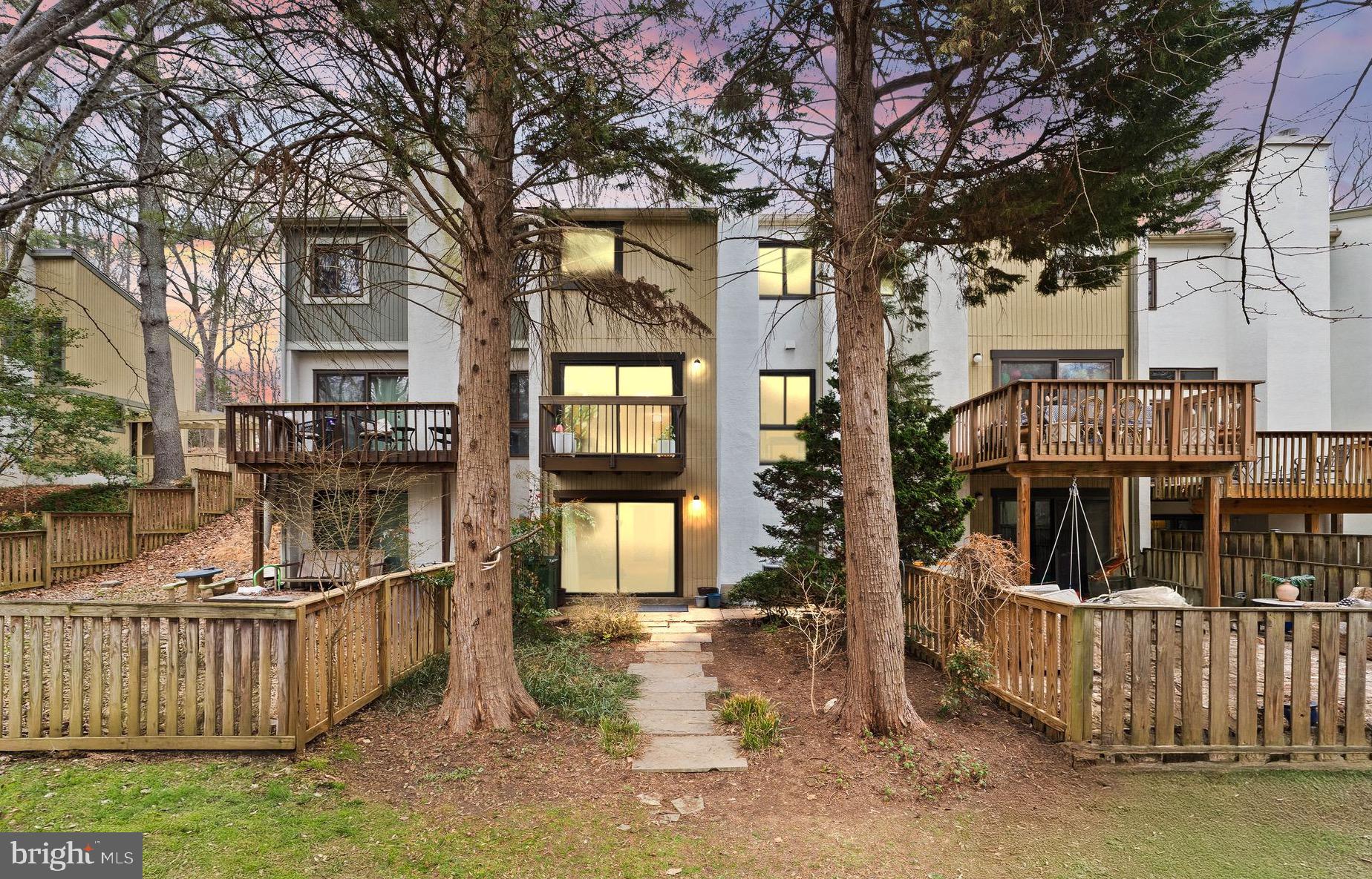 2345 Millennium Lane Reston, VA 20191 - Photo 5 of 55 a view of a brick house with large trees and wooden fence