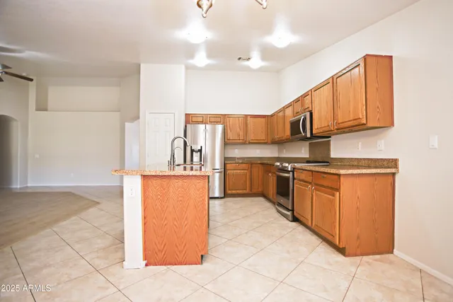 a kitchen with stainless steel appliances granite countertop a stove top oven a sink a counter space and cabinets