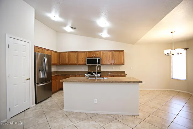 a kitchen with stainless steel appliances granite countertop a sink and a refrigerator