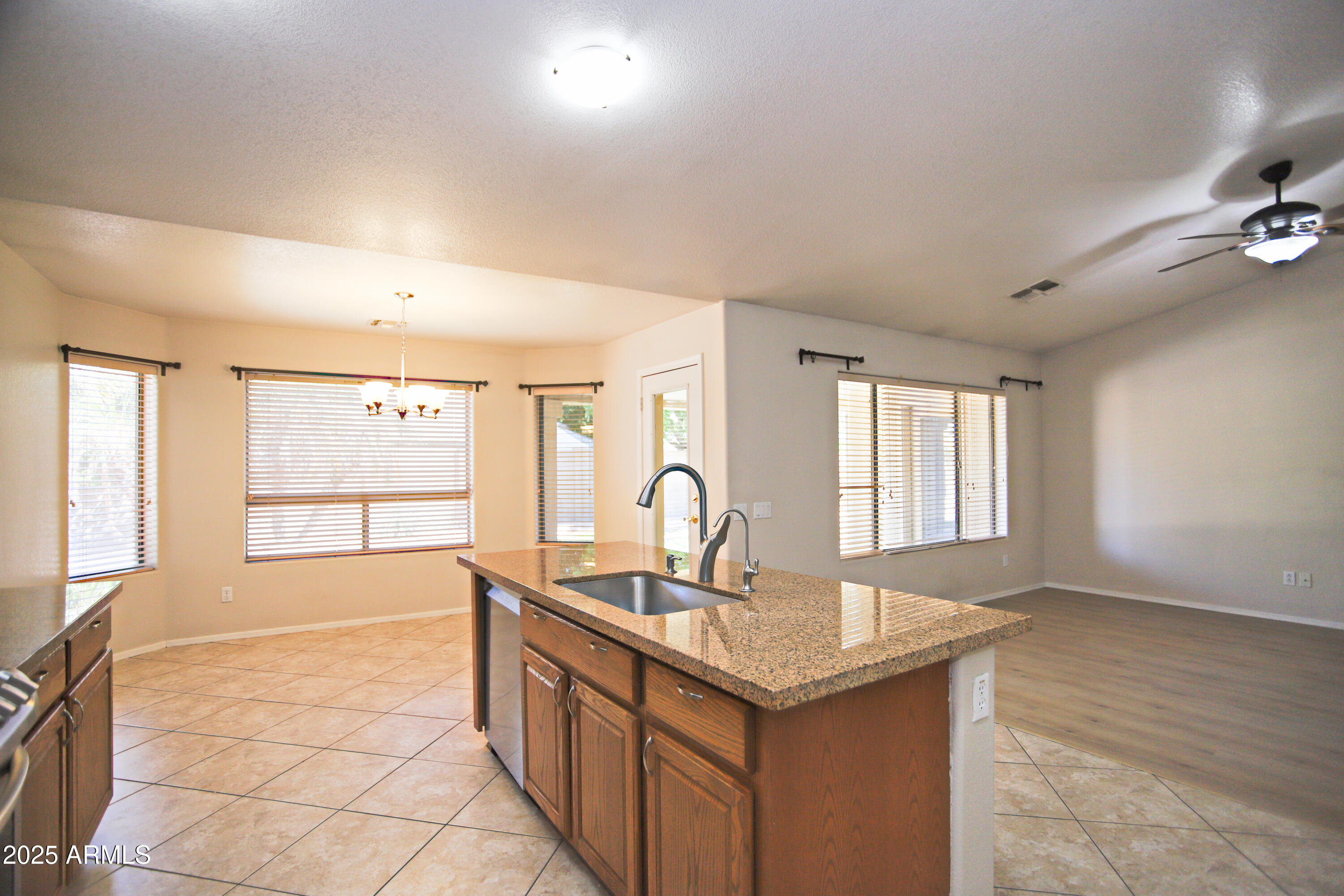 4953 South Moss Drive Chandler, AZ 85248 - Photo 17 of 50 a kitchen with granite countertop a sink and a stove