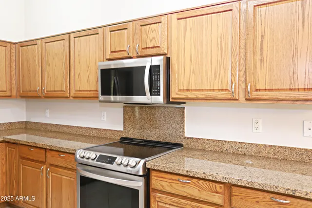 a kitchen with granite countertop cabinets stainless steel appliances and a sink