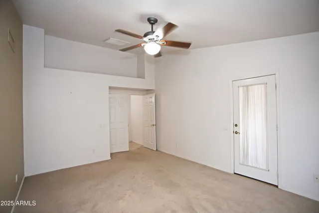 a view of an empty room with a chandelier fan