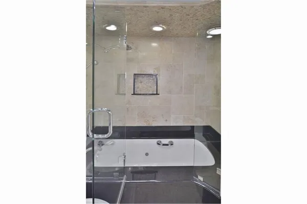 an empty room with large window and a ceiling fan