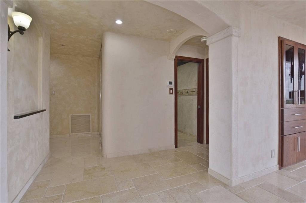 40 North Interstate Highway 35, Unit 12C2 Austin, TX 78701 - Photo 3 of 21 Corridor with stone tile floors, arched walkways, recessed lighting, and a textured wall