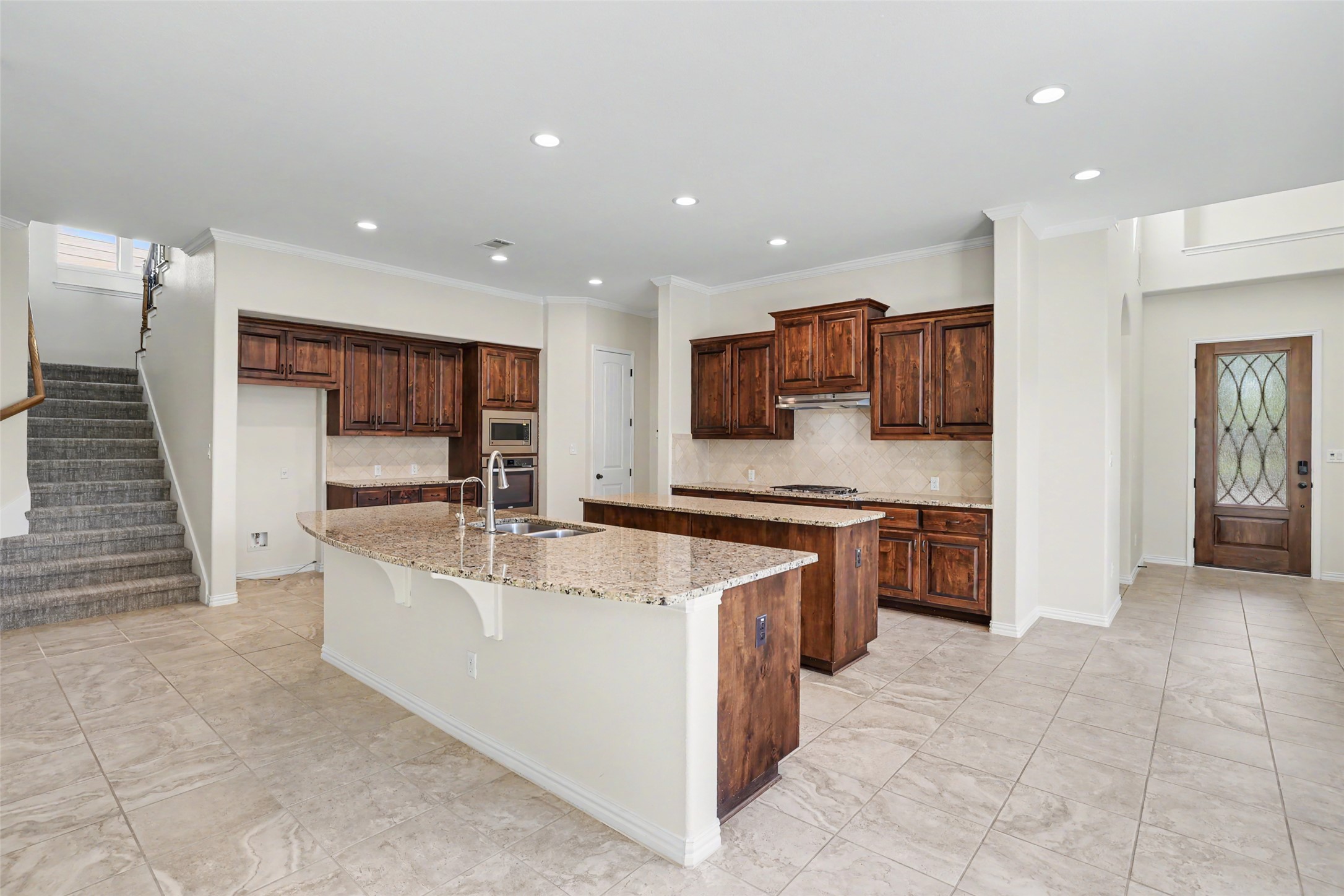 1020 Winding Way Drive Georgetown, TX 78628 - Photo 9 of 32 Kitchen with tasteful backsplash, light stone countertops, a kitchen breakfast bar, stainless steel appliances, and recessed lighting