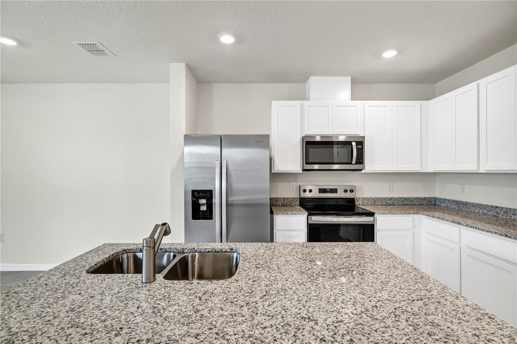 5650 Anders Way St. Cloud, FL 34771 - Photo 16 of 39 a kitchen with granite countertop a sink and stainless steel appliances