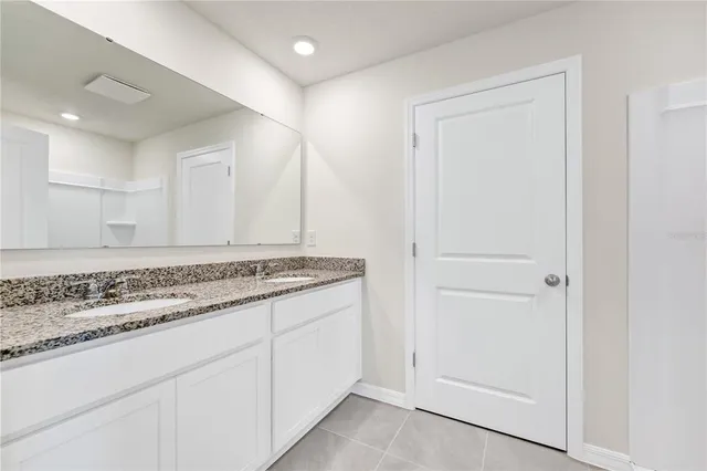 a bathroom with a granite countertop sink and a mirror