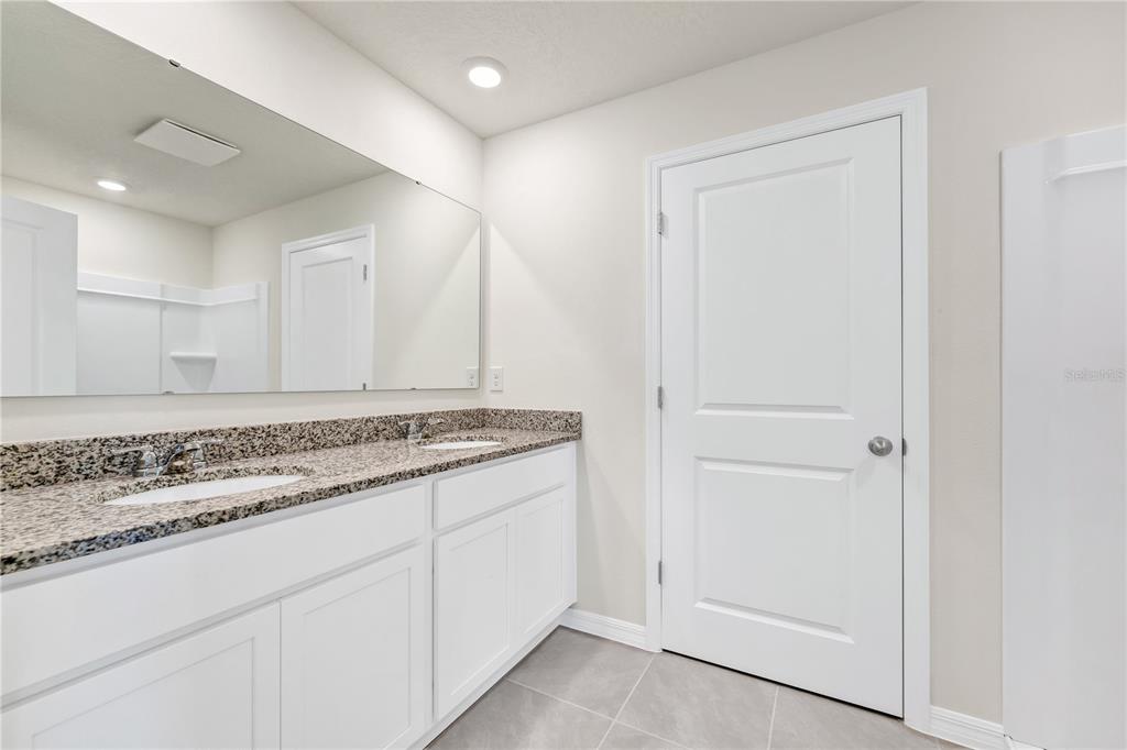 5650 Anders Way St. Cloud, FL 34771 - Photo 20 of 39 a bathroom with a granite countertop sink and a mirror