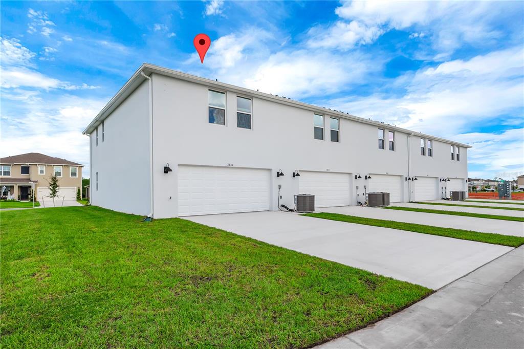 5650 Anders Way St. Cloud, FL 34771 - Photo 35 of 39 a white house with a small yard and plants