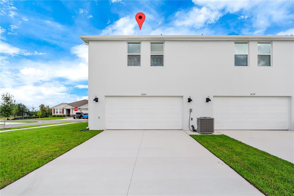 5650 Anders Way St. Cloud, FL 34771 - Photo 4 of 39 a view of a white house with a small yard and a big yard