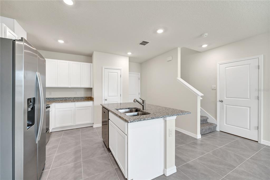 5650 Anders Way St. Cloud, FL 34771 - Photo 9 of 39 a kitchen that has a lot of white cabinets and stainless steel appliances
