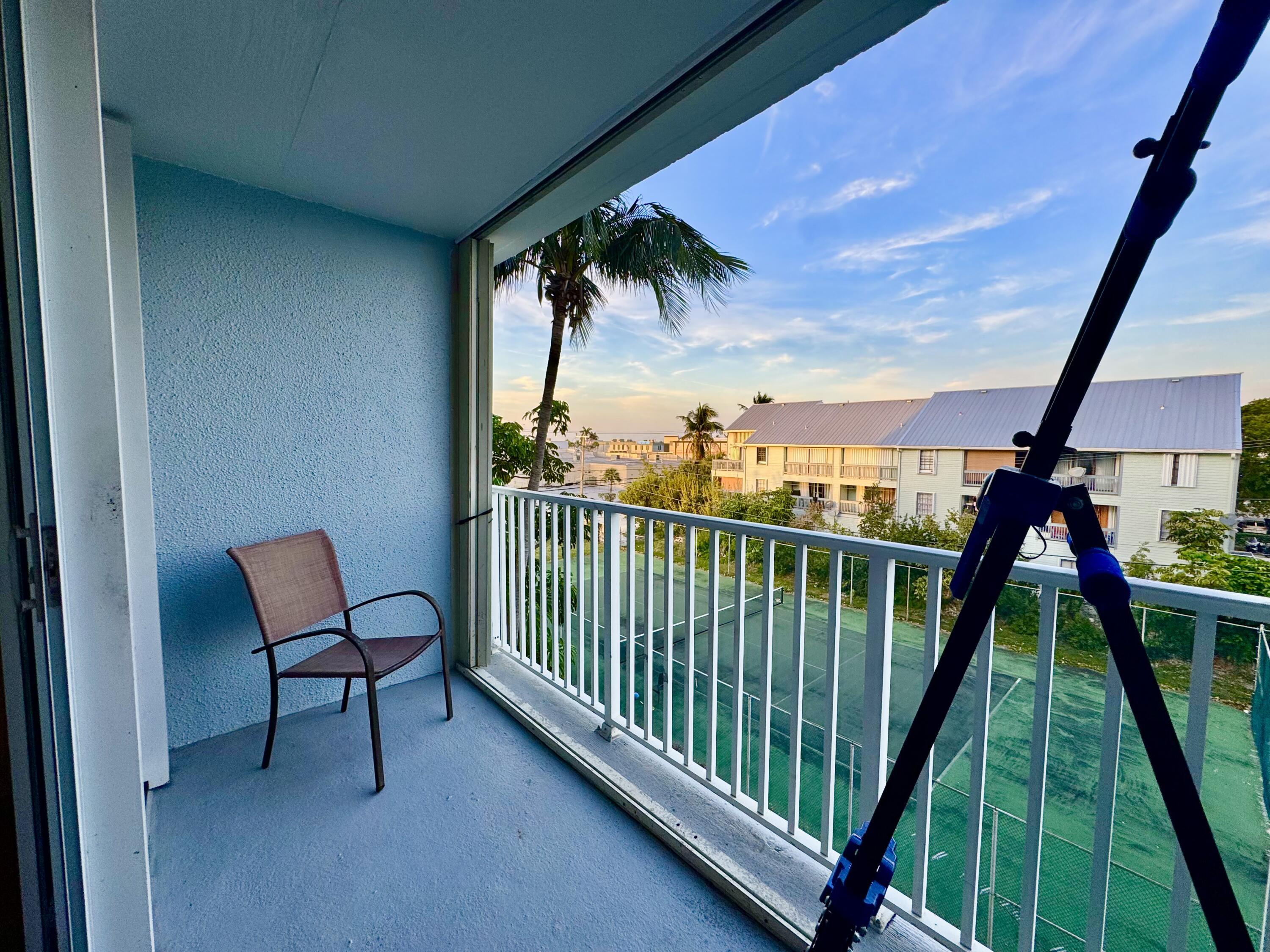 3312 Northside Drive, Unit 405 Key West, FL 33040 - Photo 13 of 25 a view of a balcony with furniture and a floor to ceiling window
