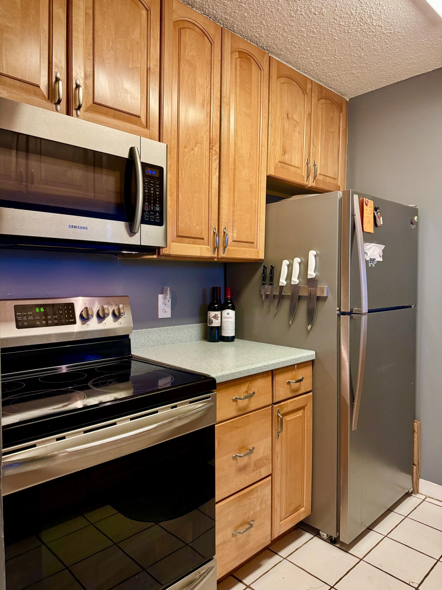 3312 Northside Drive, Unit 405 Key West, FL 33040 - Photo 8 of 25 a kitchen with stainless steel appliances granite countertop a refrigerator stove and microwave