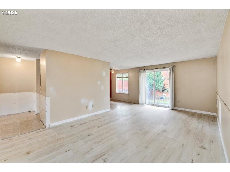 159 Southwest Florence Avenue Gresham, OR 97080 - Photo 8 of 24 a view of an empty room with wooden floor and a window