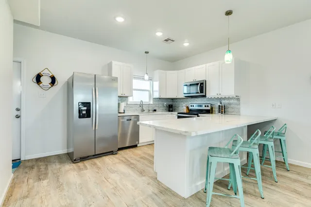 a living room with furniture and a view of kitchen
