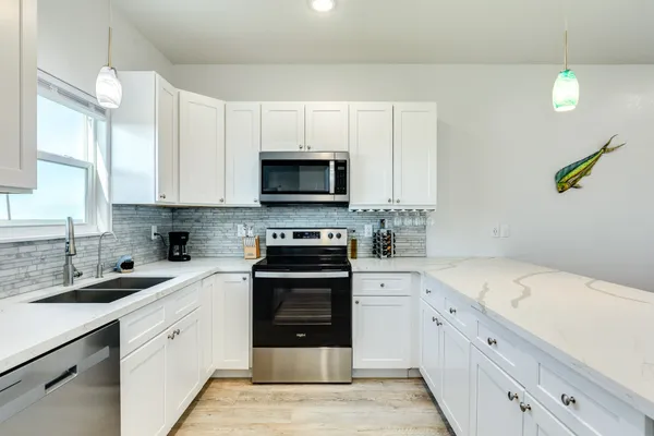 a kitchen with kitchen island granite countertop a table chairs sink and cabinets