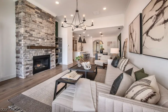 a living room with furniture a fireplace and a chandelier