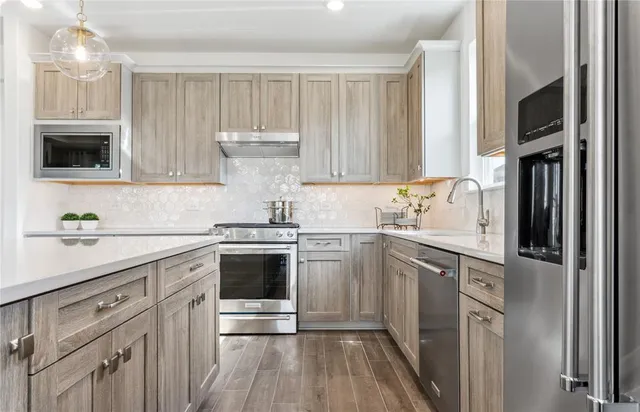 a kitchen with a sink cabinets and stainless steel appliances
