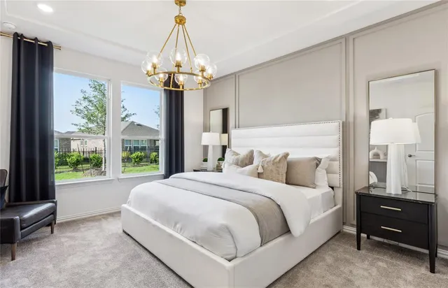 a bedroom with a bed chandelier and window