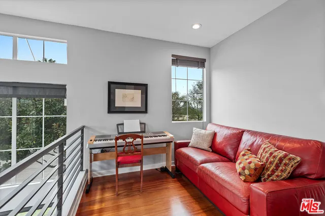 a living room with furniture a flat screen tv and a large window