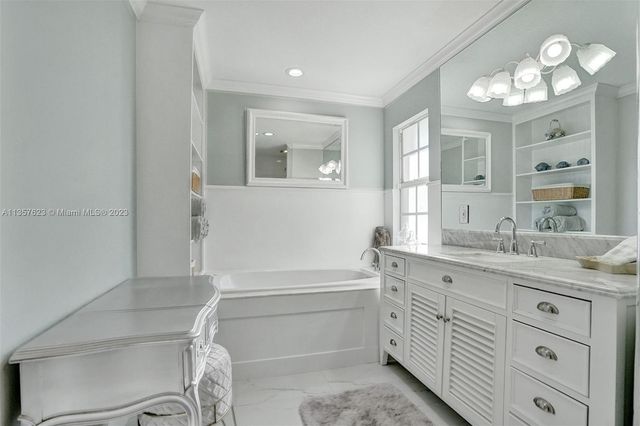 a bathroom with a double vanity sink a mirror and a bathtub