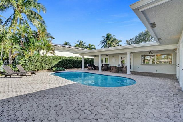 a view of a house with backyard patio and swimming pool