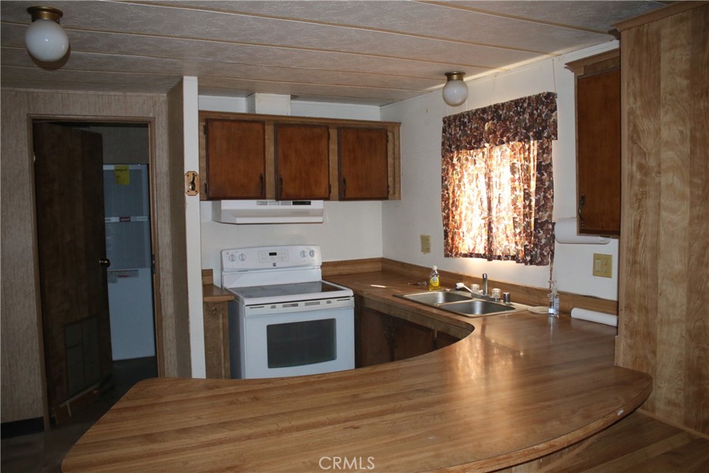 1147 Cherokee Trail Yucca Valley, CA 92284 - Photo 23 of 27 a kitchen with granite countertop a stove and a wooden floors