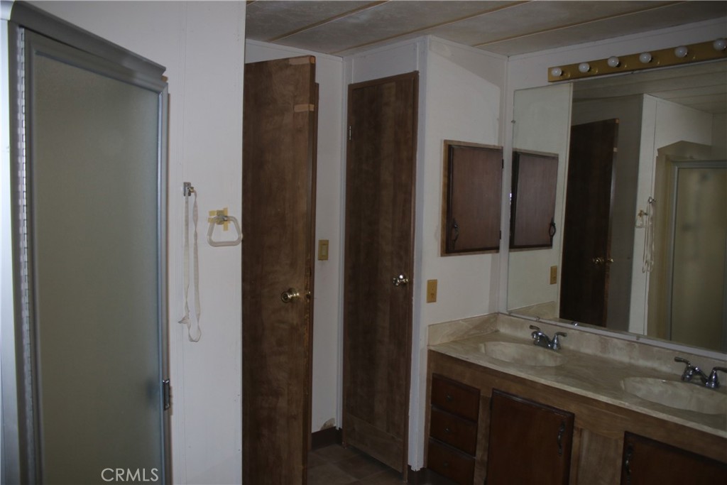 1147 Cherokee Trail Yucca Valley, CA 92284 - Photo 10 of 27 a bathroom with a granite countertop sink and a mirror
