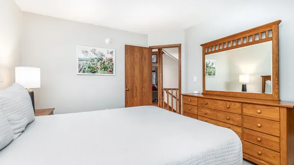 a bedroom with a large bed and a flat tv screen on dresser