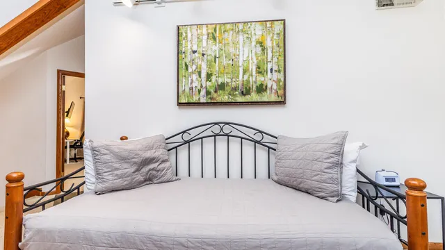 a bedroom with a bed a flat screen tv and dresser