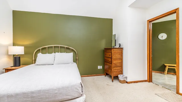 a bedroom with a large bed and a flat tv screen on dresser