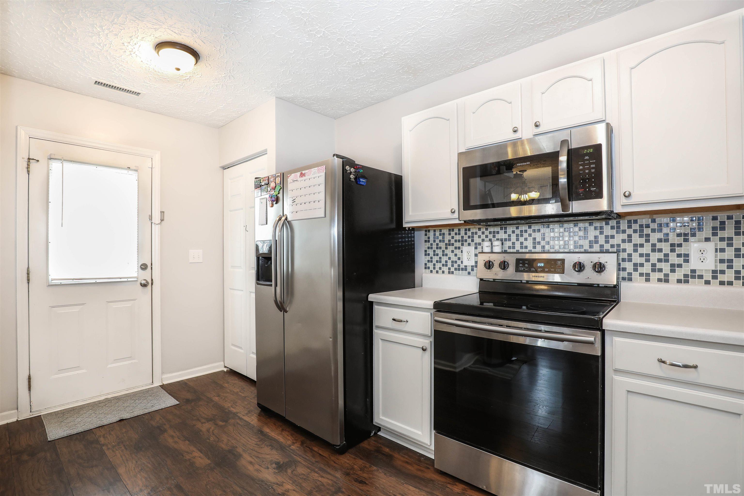 5805 Wynmore Road Raleigh, NC 27610 - Photo 11 of 20 a kitchen with a stove microwave and refrigerator