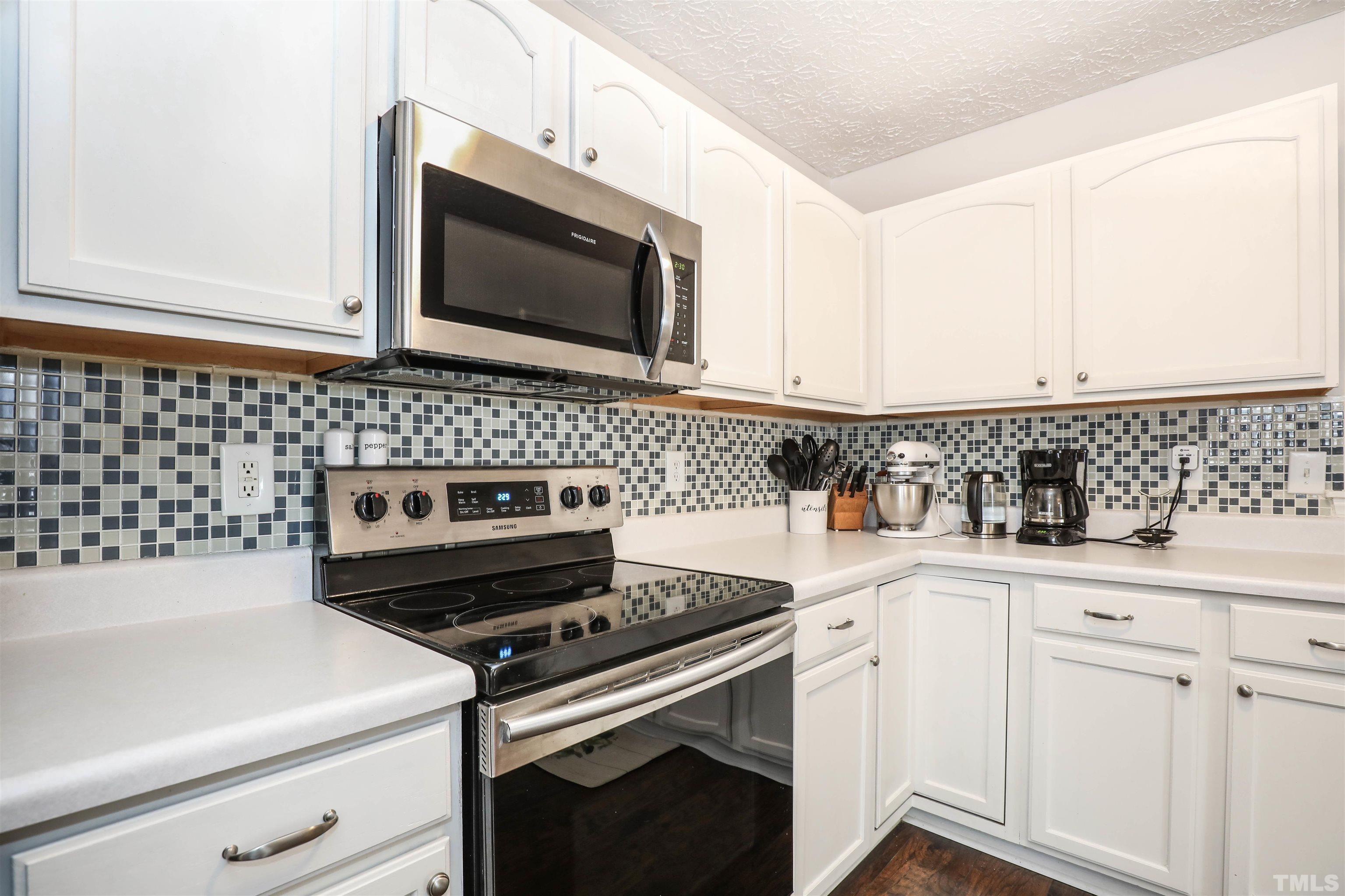 5805 Wynmore Road Raleigh, NC 27610 - Photo 13 of 20 a kitchen with granite countertop white cabinets and black appliances