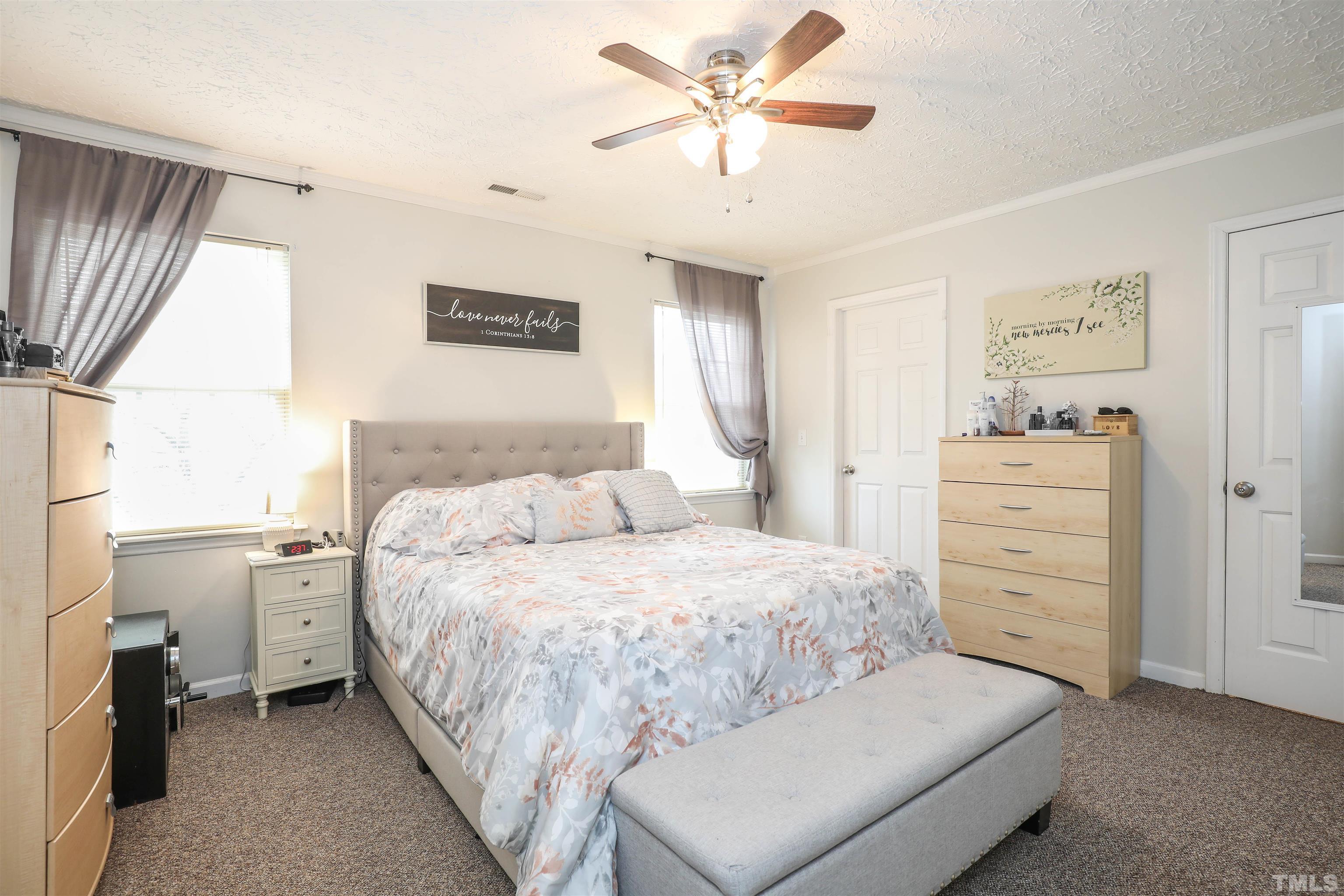 5805 Wynmore Road Raleigh, NC 27610 - Photo 15 of 20 a bedroom with a bed and a chandelier