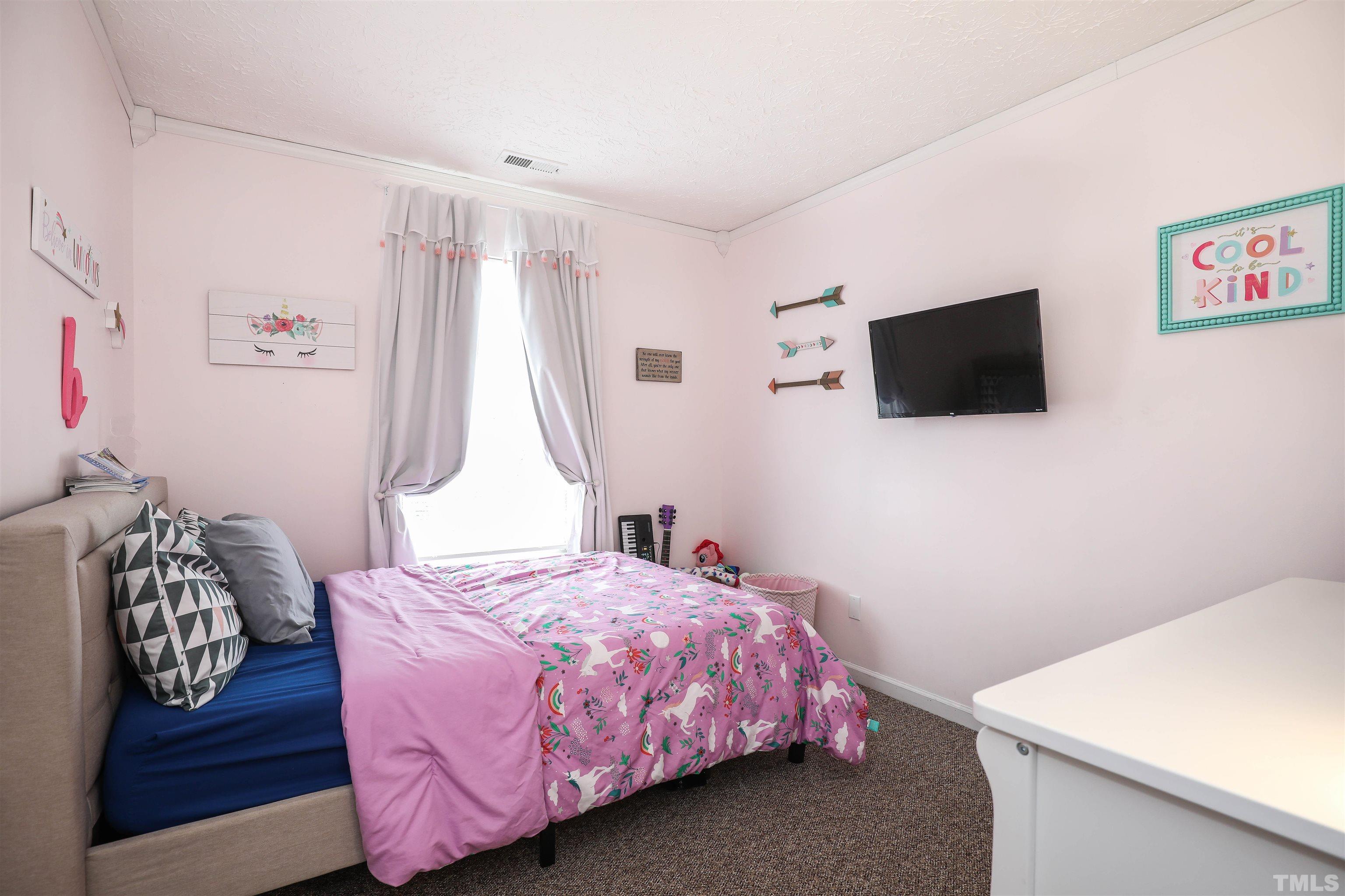5805 Wynmore Road Raleigh, NC 27610 - Photo 17 of 20 a bedroom with a bed and a flat screen tv