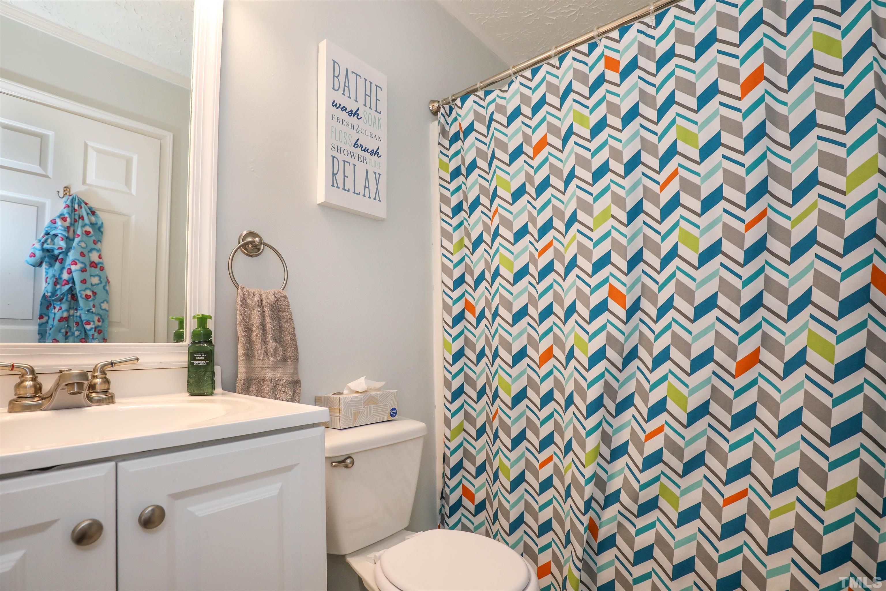 5805 Wynmore Road Raleigh, NC 27610 - Photo 19 of 20 a bathroom with a sink mirror vanity and toilet