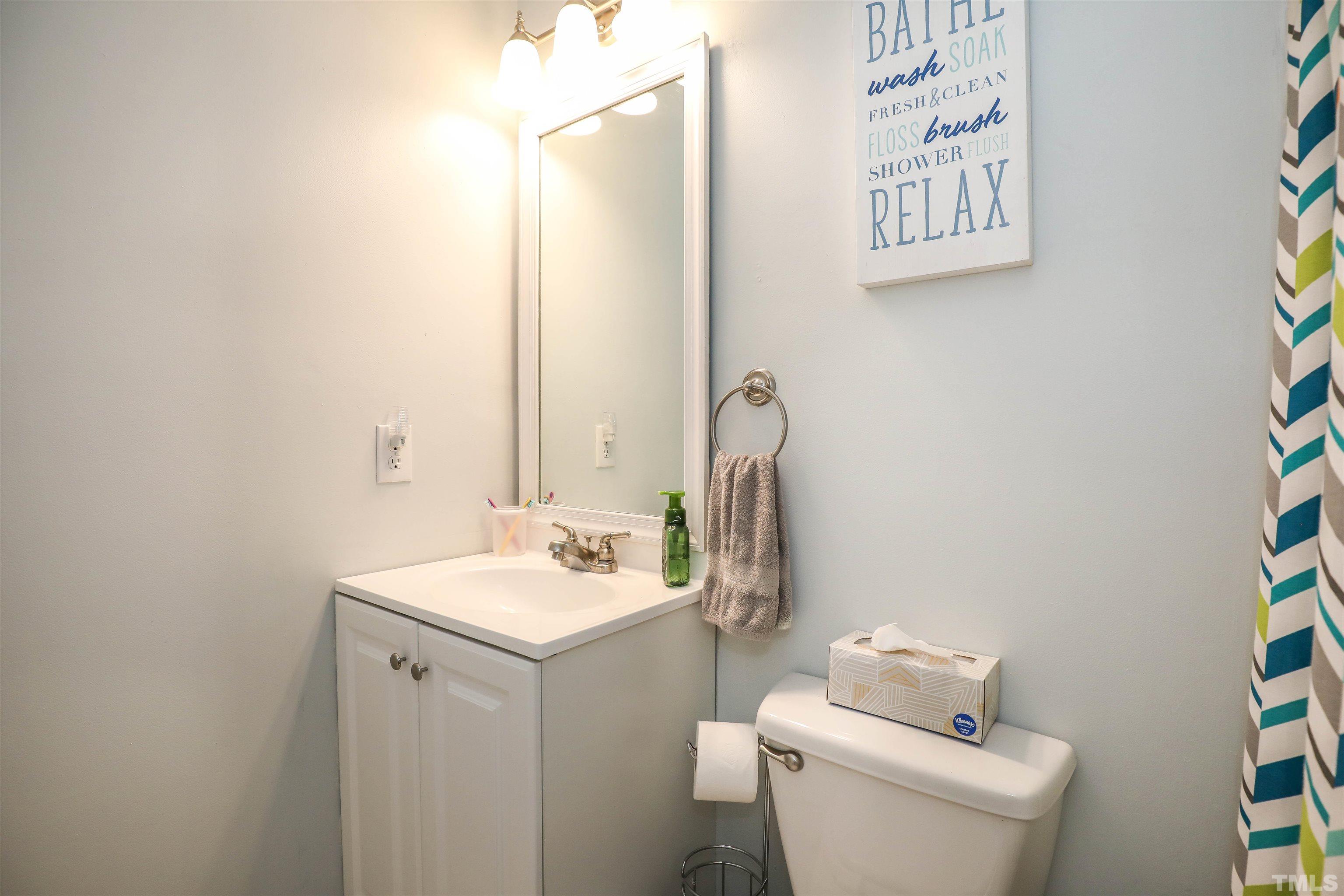 5805 Wynmore Road Raleigh, NC 27610 - Photo 20 of 20 a bathroom with a toilet sink and mirror