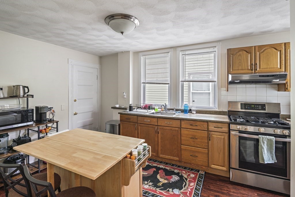 105 Walnut Street Somerville, MA 02145 - Photo 18 of 37 a kitchen with a stove a sink and a refrigerator
