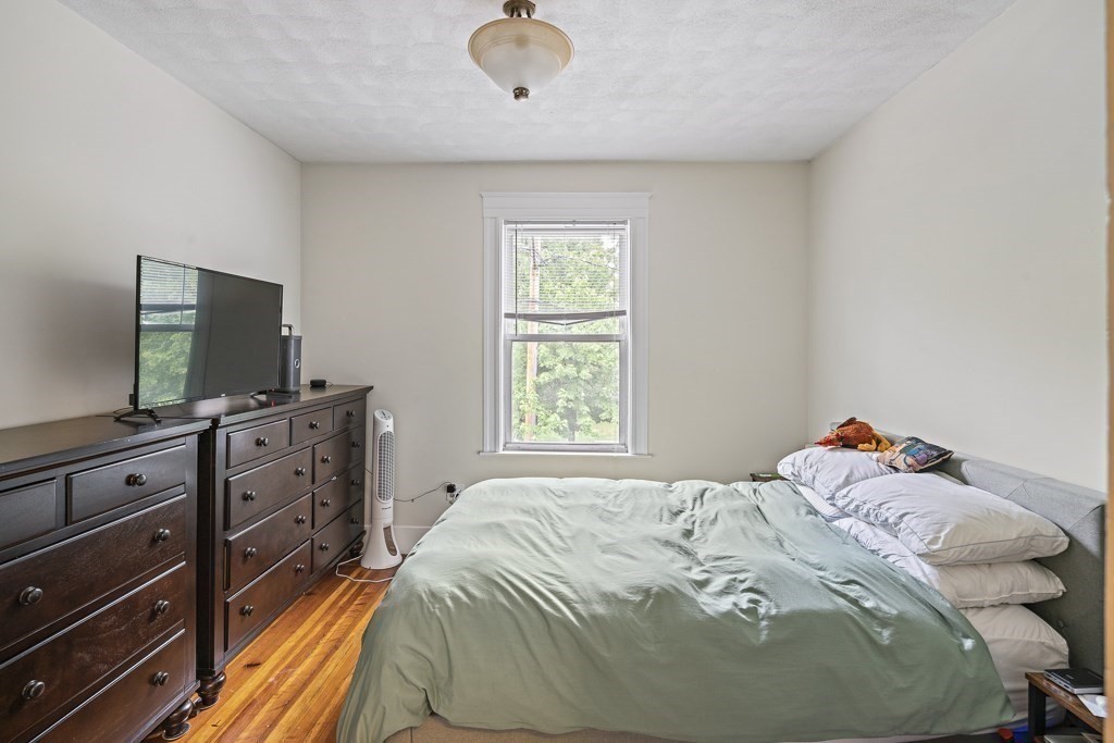 105 Walnut Street Somerville, MA 02145 - Photo 19 of 37 a bedroom with a bed and a flat screen tv