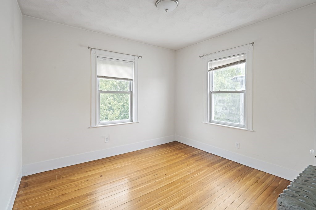 105 Walnut Street Somerville, MA 02145 - Photo 29 of 37 a view of an empty room with wooden floor and a window
