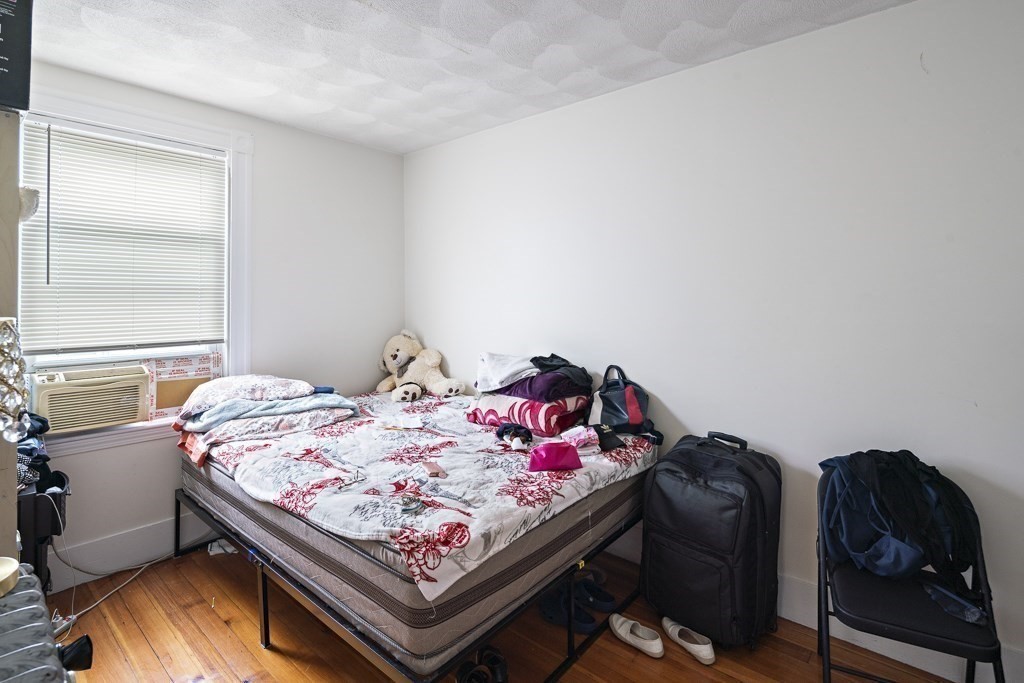 105 Walnut Street Somerville, MA 02145 - Photo 30 of 37 a bed sitting in a bedroom next to a window