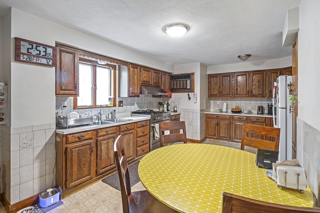 105 Walnut Street Somerville, MA 02145 - Photo 4 of 37 a kitchen with stainless steel appliances granite countertop a sink stove and refrigerator