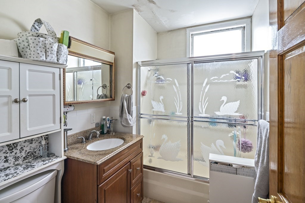 105 Walnut Street Somerville, MA 02145 - Photo 8 of 37 a bathroom with a granite countertop sink mirror and vanity